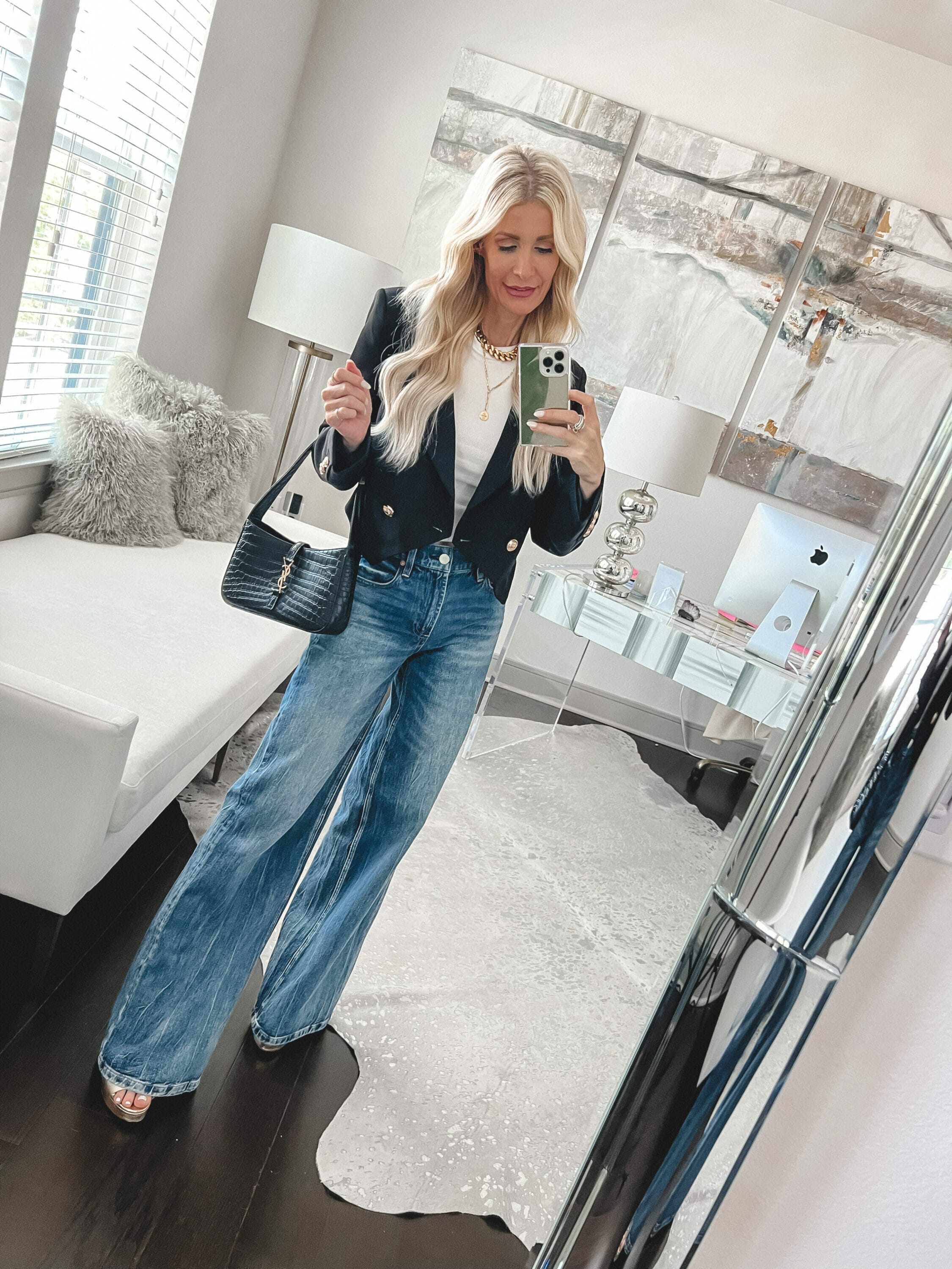 Over 40 fashion influencer wearing baggy jeans with a simple white tee and cropped blazer as one of fall's hottest denim trends.