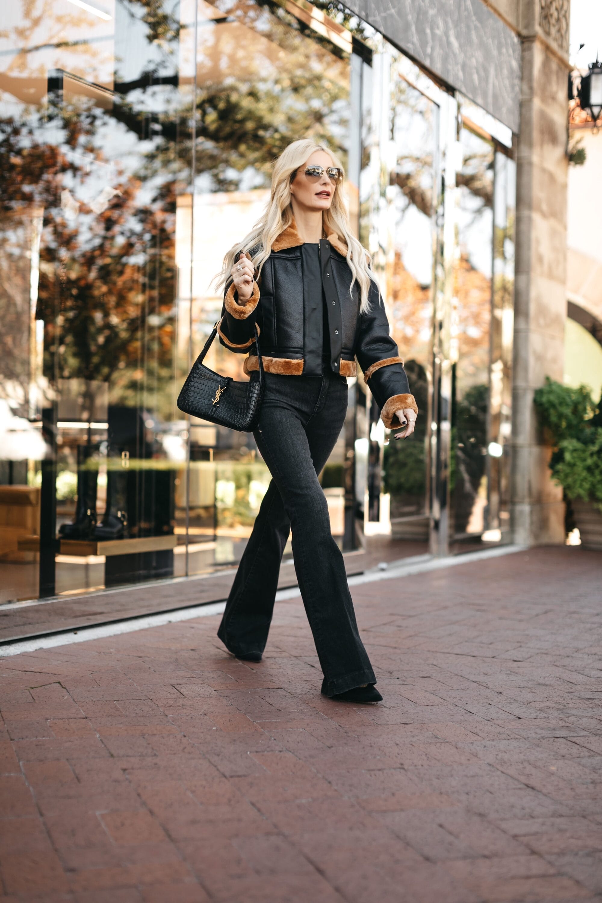 Dallas fashion influencer for women over 40 wearing a faux fur trimmed moto jacket with black jeans as one of 5 chic Thanksgiving outfits.