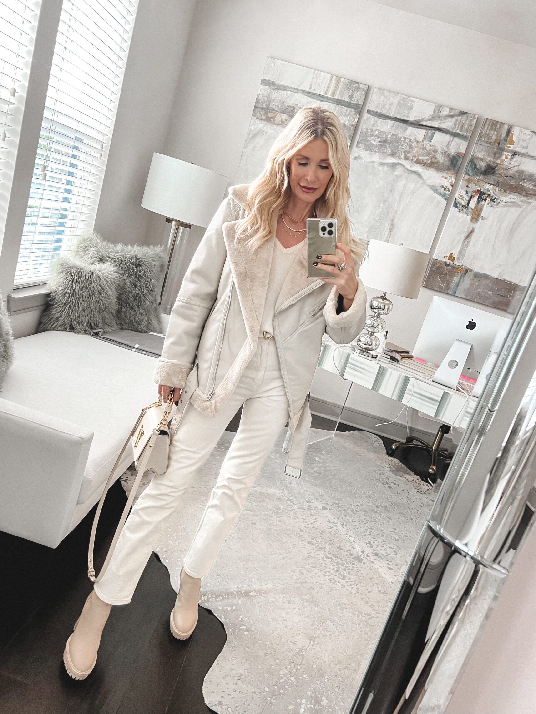 Dallas fashion influencer wearing a white faux fur jacker with ivory jeans and white boots.