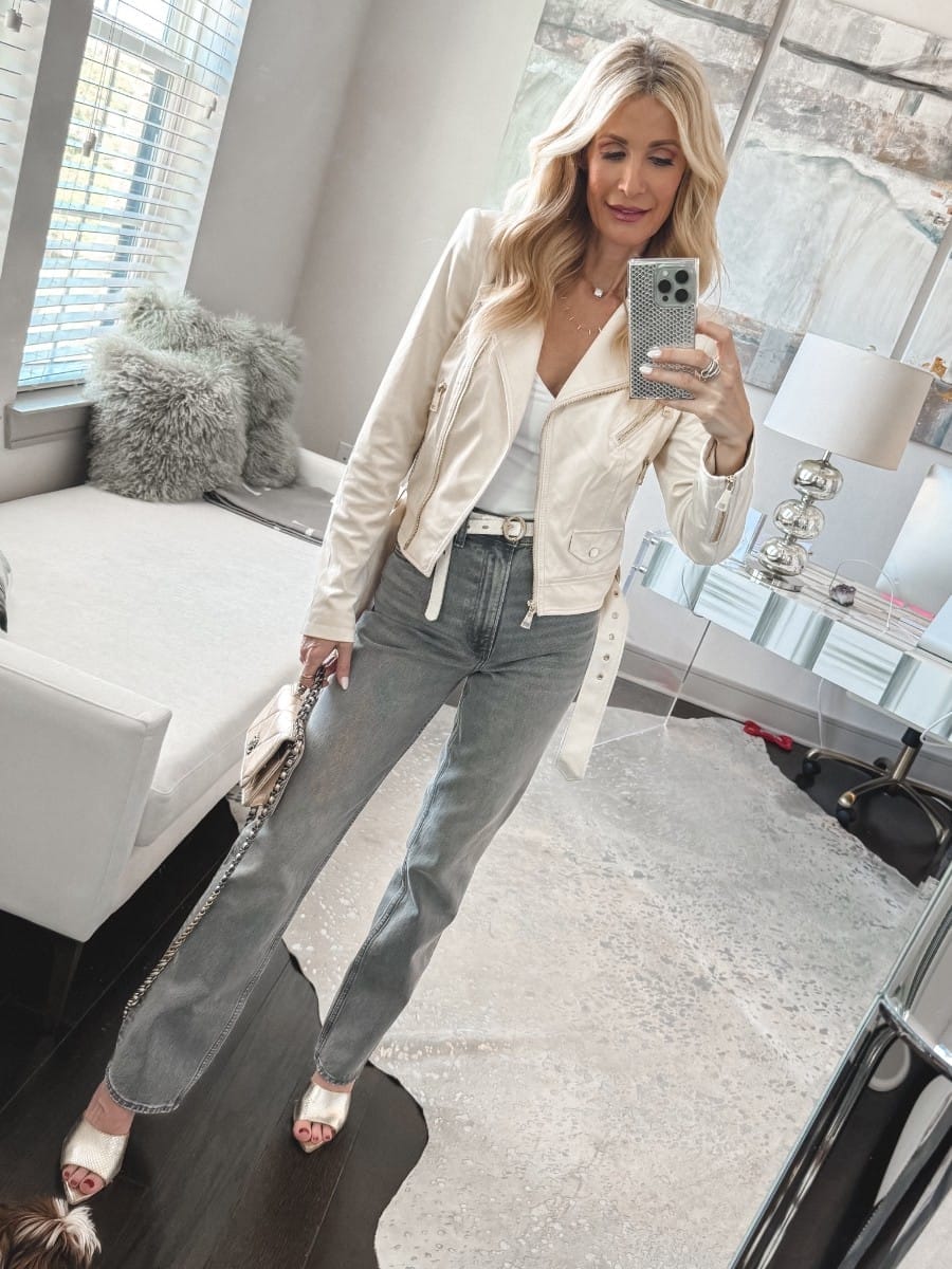 Over 40 fashion blogger wearing gray jeans with a ivory suede jacket and silver heels as one of the hottest denim trends in her spring denim edit.