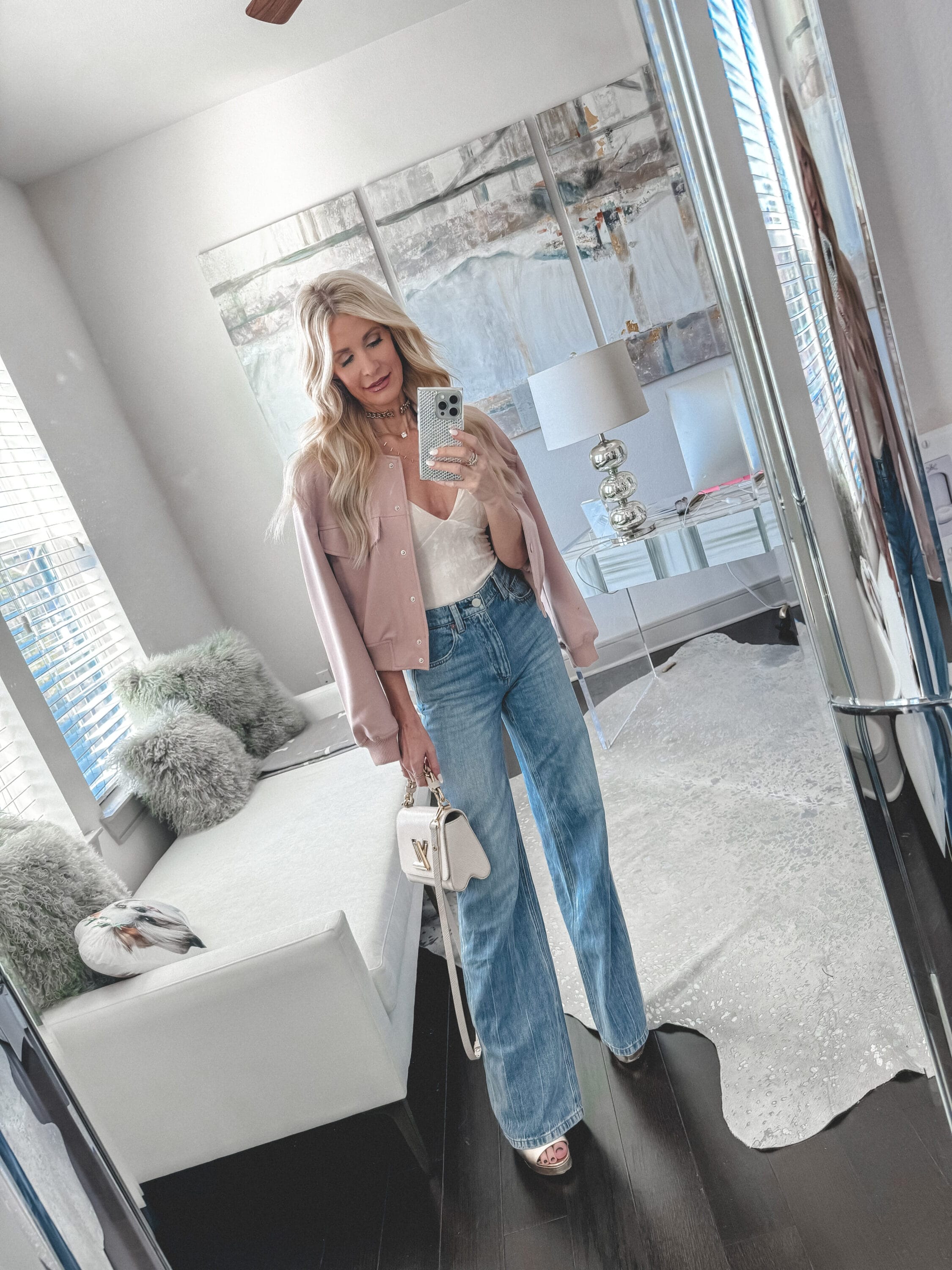 Dallas fashion women over 40 wearing a blush bomber jacket with Alice & Olivia wide leg jeans as one of the hottest denim trends in her spring denim edit.