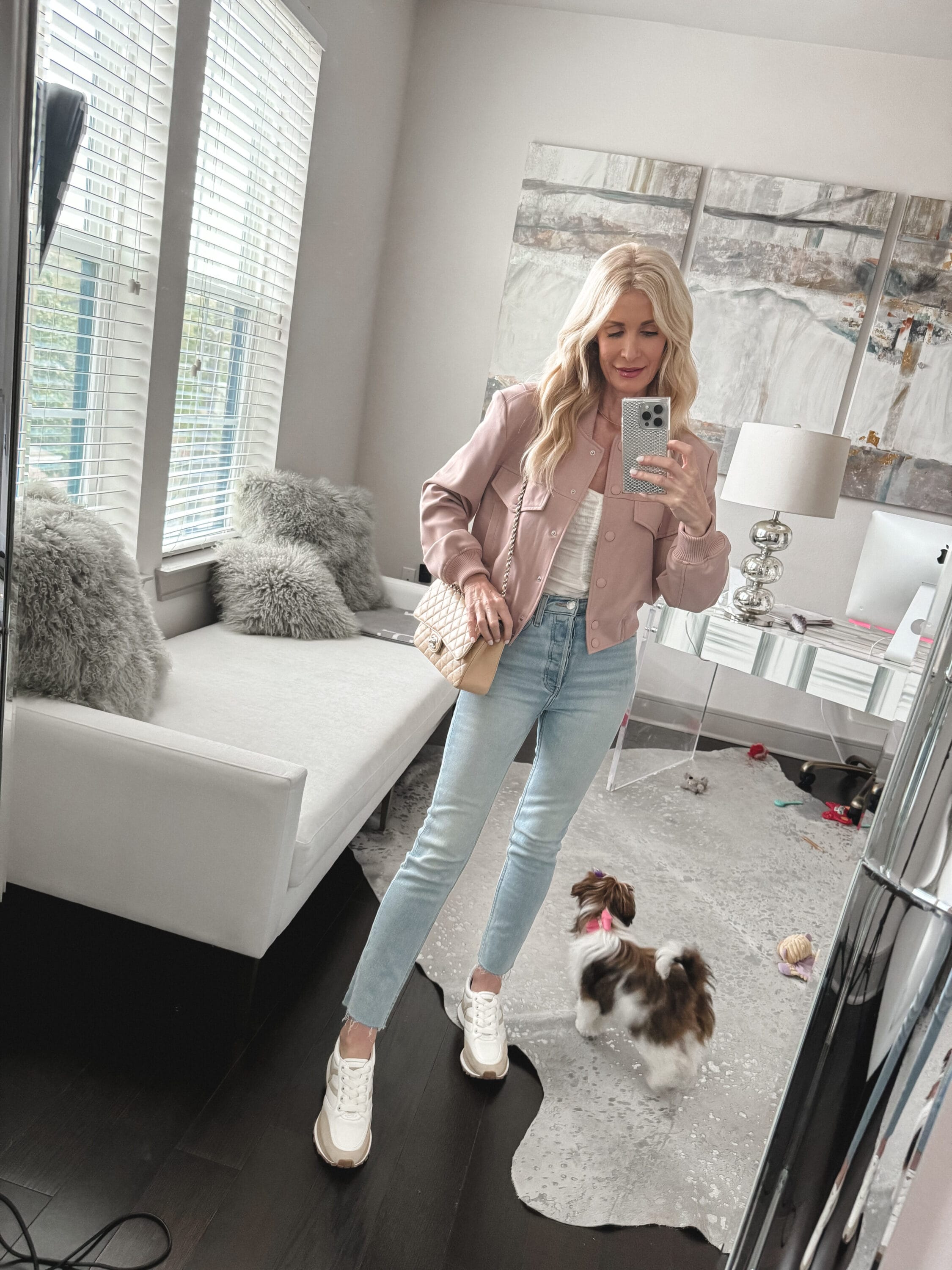 Woman over 40 wearing a blush cargo jacket with cropped straight leg jeans and veronica beard sneakers as one of the best spring jackets of 2024.