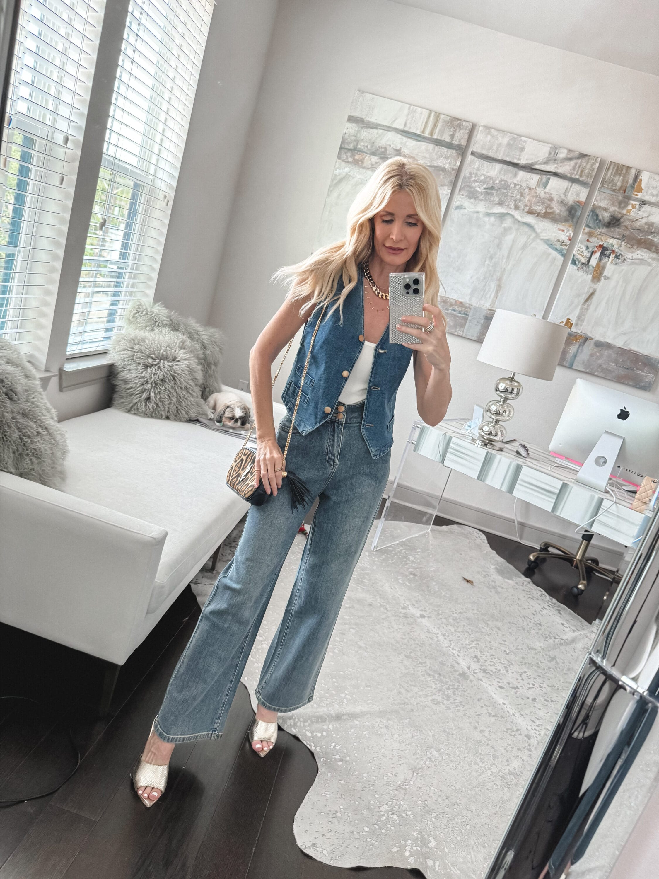 Dallas woman over 40 styling a denim vest as a spring top with wide leg jeans with no pockets and gold mules as one of 5 stylish spring looks.