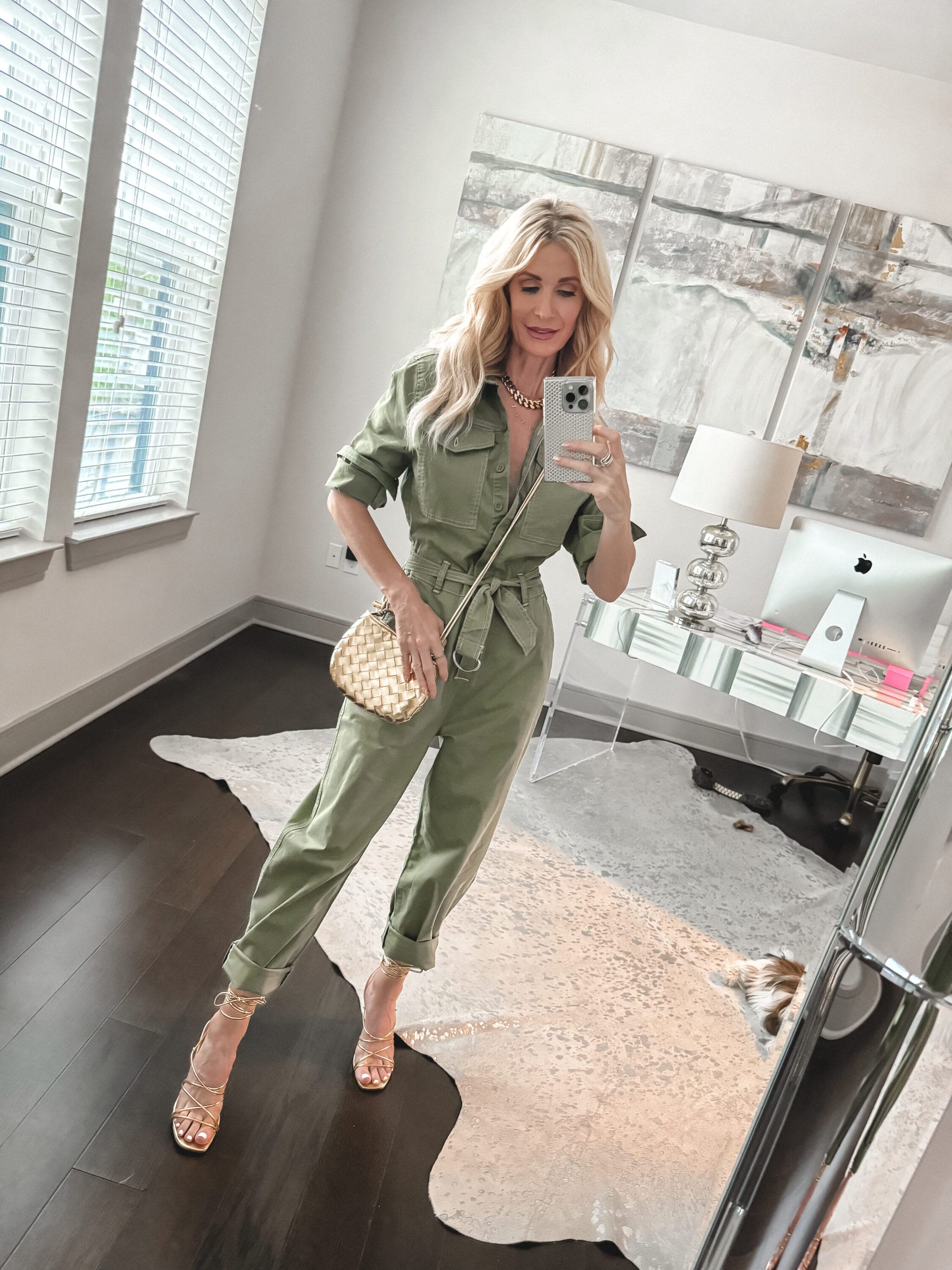 Dallas fashion influencer over 40 wearing a sage green jumpsuit with gold lace up heels and a gold handbag as examples of under $50 spring wardrobe essentials.